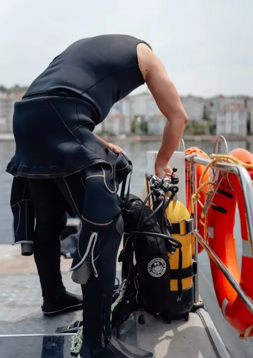 Plongeur qui vérifie son matériel sur le pont