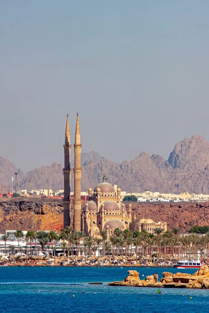 Une mosquée aux deux minarets devant les montagnes du désert