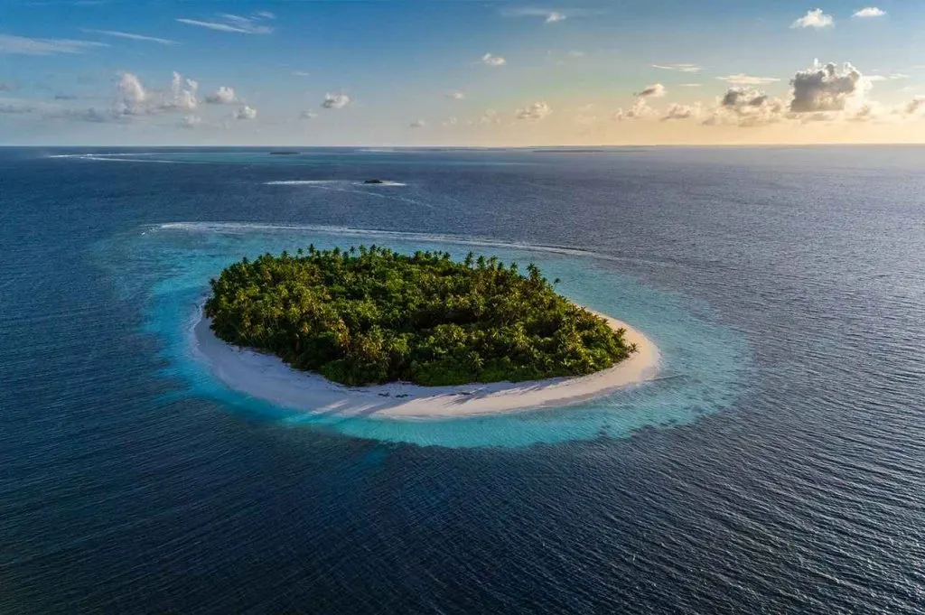 Île entourée de son récif au coucher du soleil