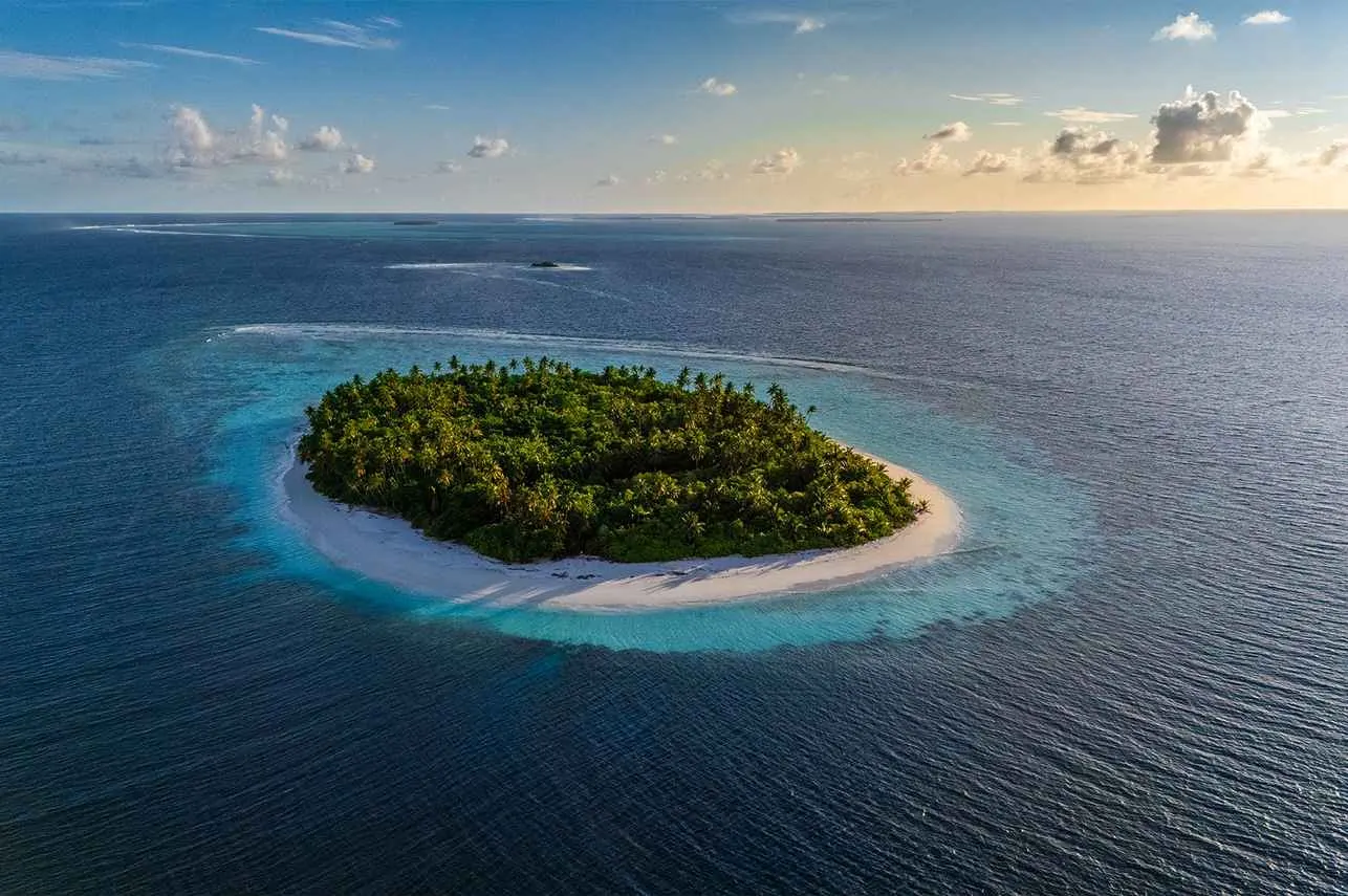 Île entourée de son récif au coucher du soleil, Maldives