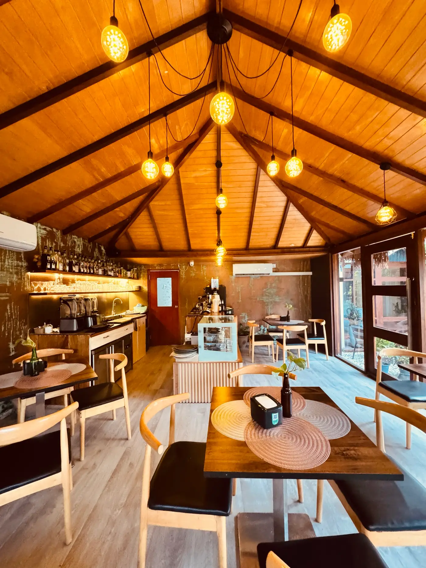 Intérieur en bois du Cafe Eden, avec des suspensions lumineuses