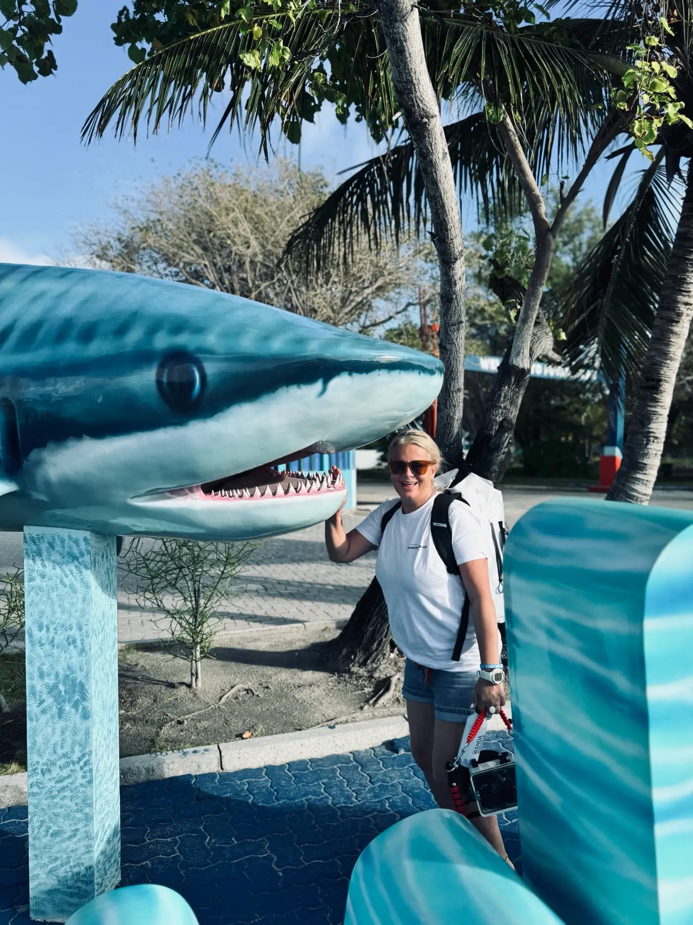 Sarah sourit à côté d'une statue de requin sur l'île de Fuvahmulah
