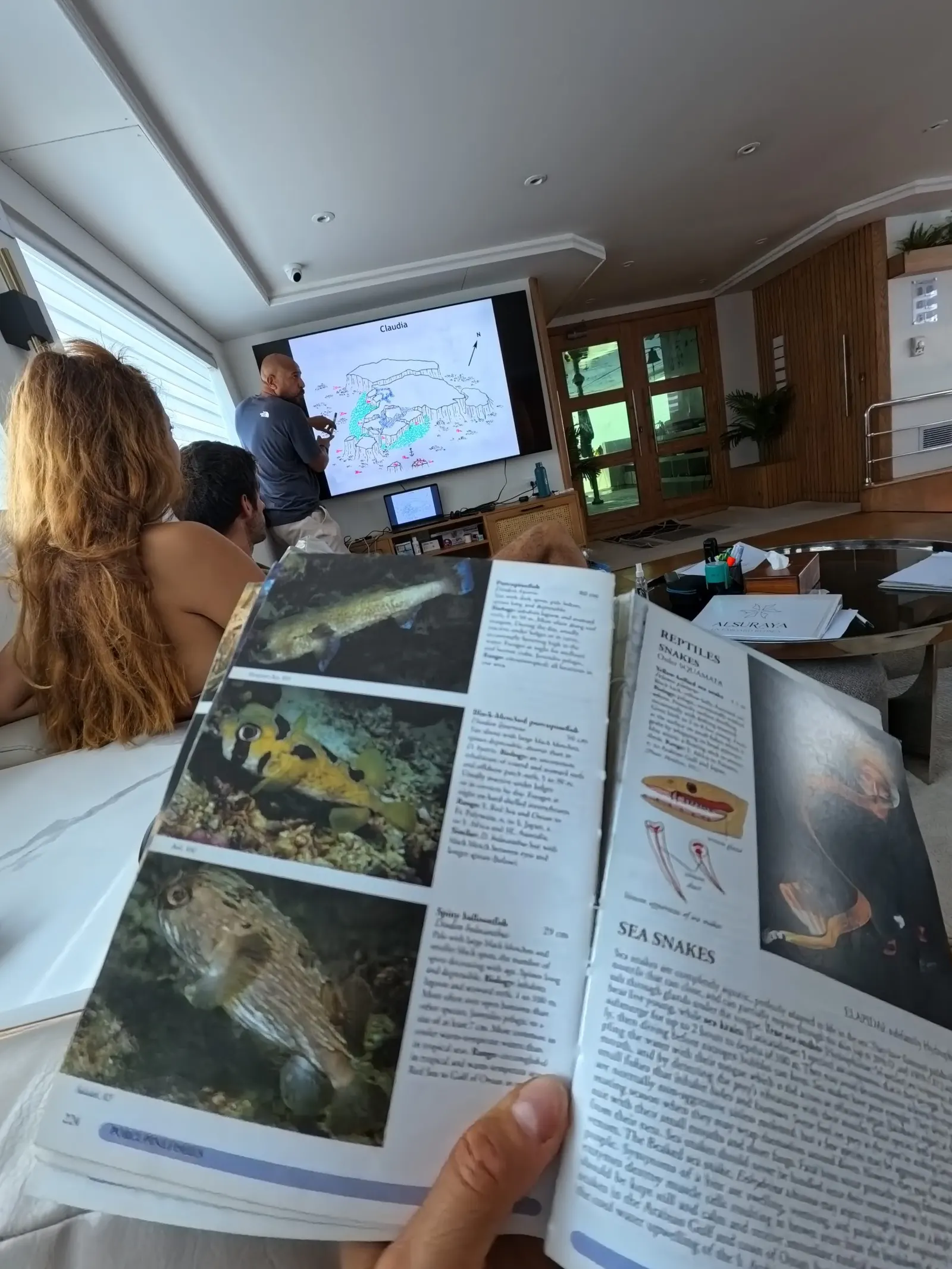 Briefing avec un livre d’identification des poissons à bord
