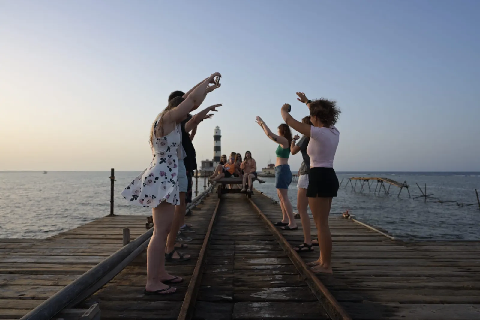 Amis sur le ponton du phare de Daedalus au coucher du soleil